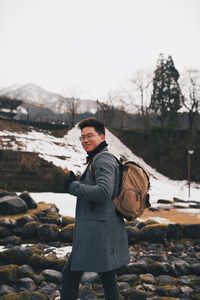 Side view of young man standing on snow covered land