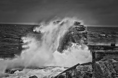 Waves splashing on rocks against sea