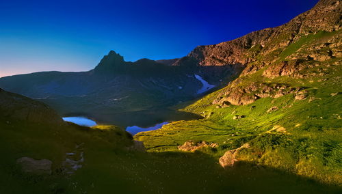 Scenic view of mountains against clear blue sky