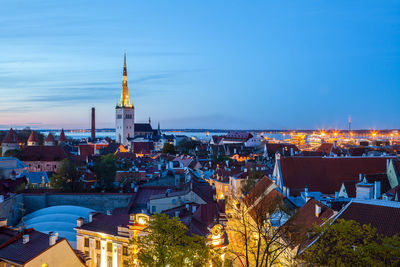 High angle view of illuminated cityscape against blue sky