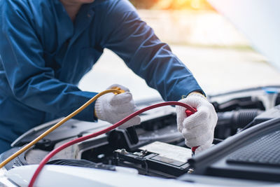 Midsection of man repairing car