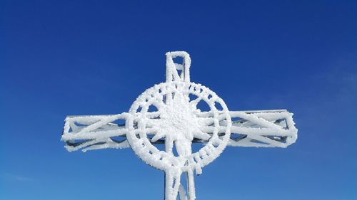 Low angle view of cross against clear blue sky