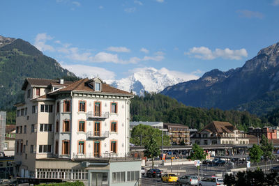 Buildings in town against cloudy sky