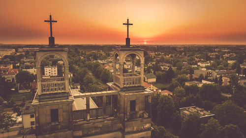 Aerial view of buildings in city at sunset