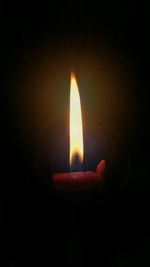 Close-up of lit candle in dark room