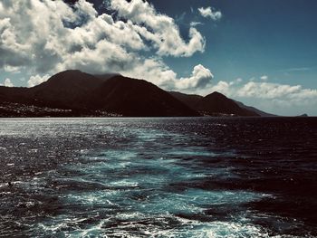 Scenic view of sea and mountains against sky