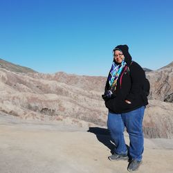Man standing on mountain against clear blue sky