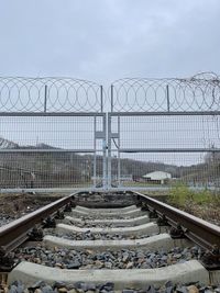 Railroad tracks against cloudy sky
