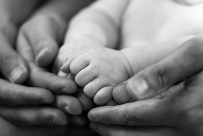 Cropped image of baby on bed