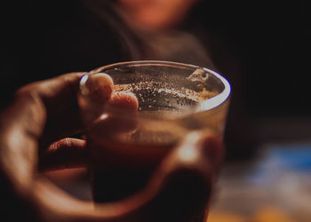 Cropped hand holding drink in restaurant