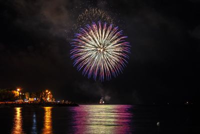 Firework display over river at night