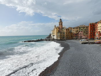 Buildings by sea against sky in city