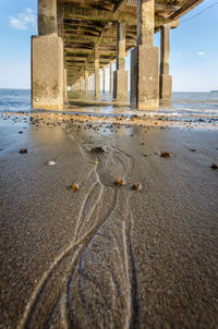 Curves and stones left by the sea tide under the pier