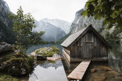 Built structure by lake against mountains