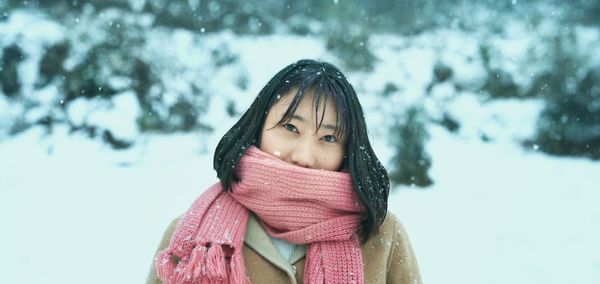 Portrait of woman with scarf on face in snow