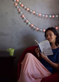 Young woman sitting on book