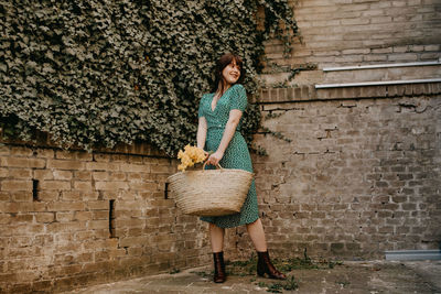 Full length of woman standing against wall