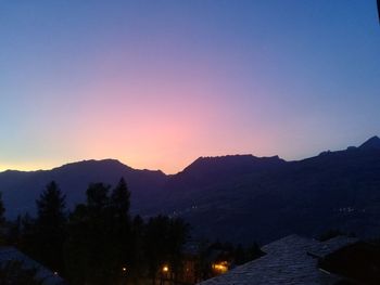 Scenic view of silhouette mountains against clear sky during sunset