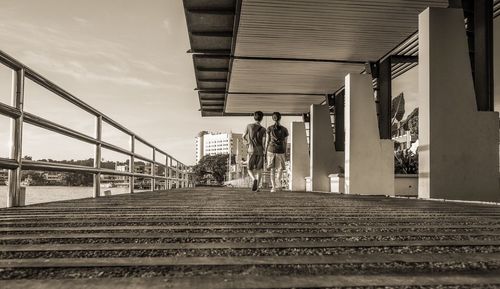 People walking on bridge against sky