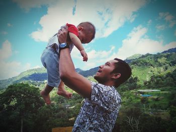 Full length of father and daughter against sky