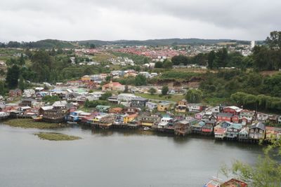 Townscape by river against sky