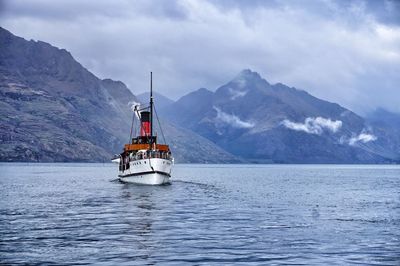 Ship in sea against mountain