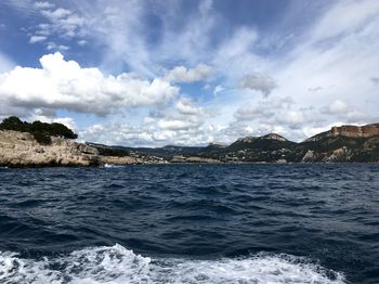 Scenic view of sea and mountains against sky