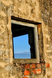 Low angle view of window on damaged building