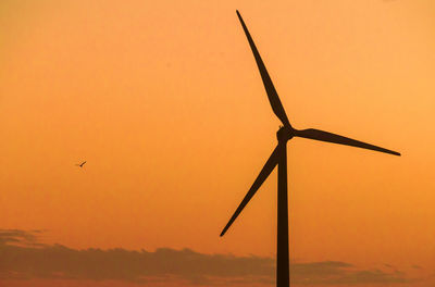 Low angle view of windmill against sky during sunset