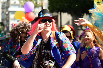 Happy woman holding multi colored balloons in park