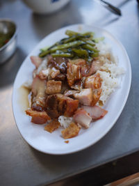 Barbecued red pork and crispy pork in sauce with rice .