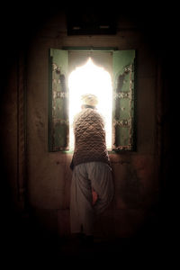 Full length of woman standing in illuminated building