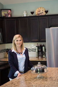 Portrait of woman standing in kitchen at home