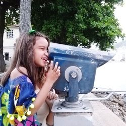 Side view of a smiling girl holding plant