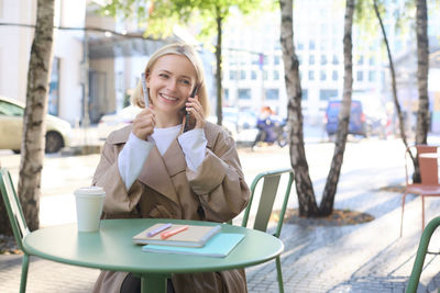 Young businesswoman using laptop while sitting on table