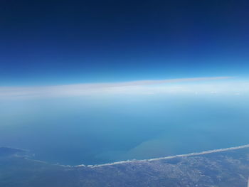 Aerial view of sea against blue sky