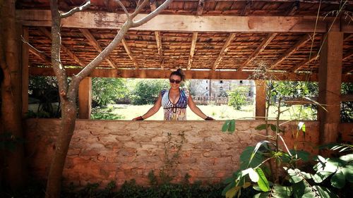 Full length of woman standing against tree