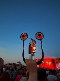 Rear view of woman holding illuminated light bulb