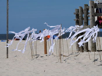 Clothes drying on beach against clear sky