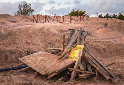 Text on wood against sky