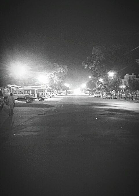 CARS PARKED ON ILLUMINATED STREET AT NIGHT