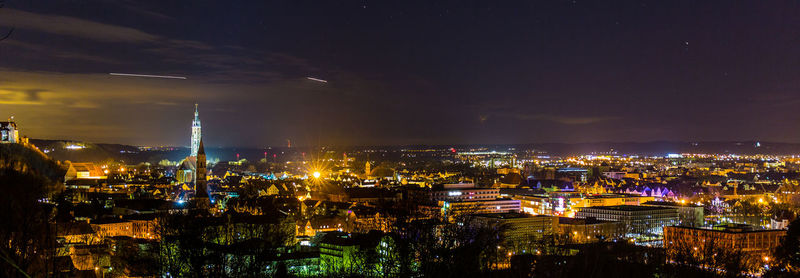 Illuminated cityscape against sky at night