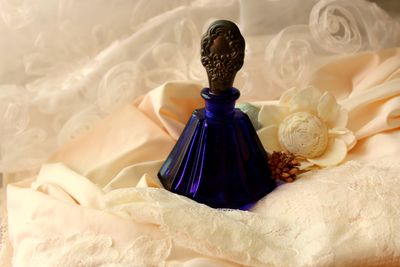 Close-up of perfume bottle on dress