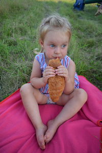 Portrait of boy eating food on field