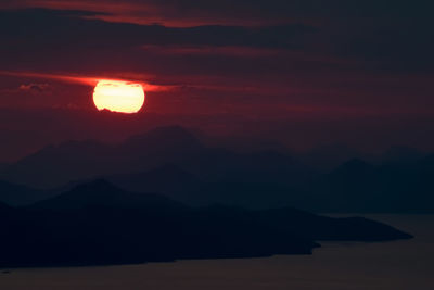 Scenic view of silhouette mountains against romantic sky at sunset