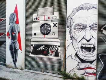 Statue of man with graffiti on wall