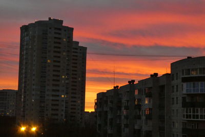 Modern buildings against sky during sunset