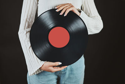 Woman with vinyl record. listening to music from analog record. retro music party. playing music