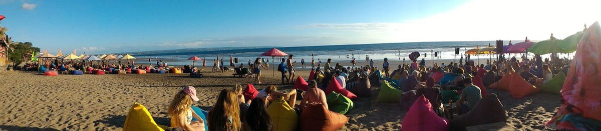 Panoramic view of people at beach against sky