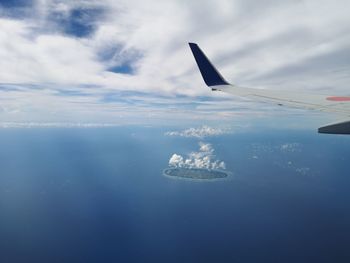 Airplane flying over sea against sky